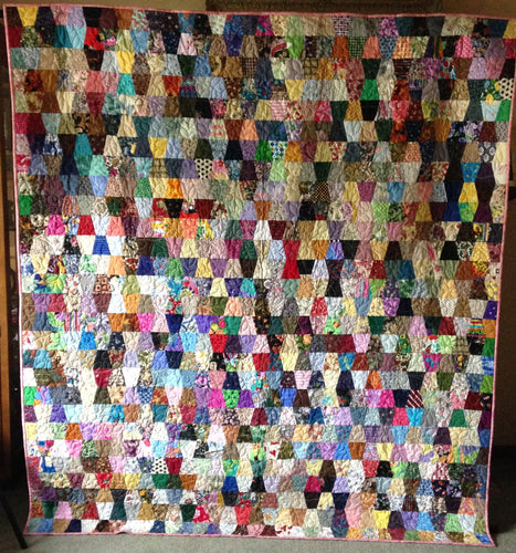 Queen sized quilt made with precut scrappy tumblers.